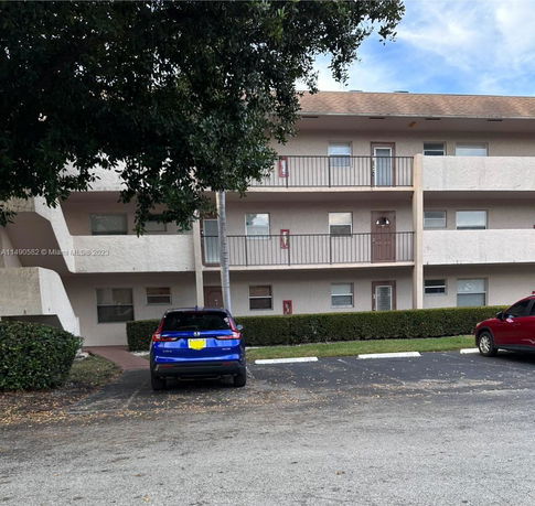 Front view of a three-story apartment building with balconies.