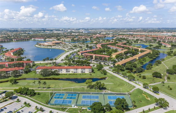 Panoramic view of a residential area with interconnected waterways and tennis courts.