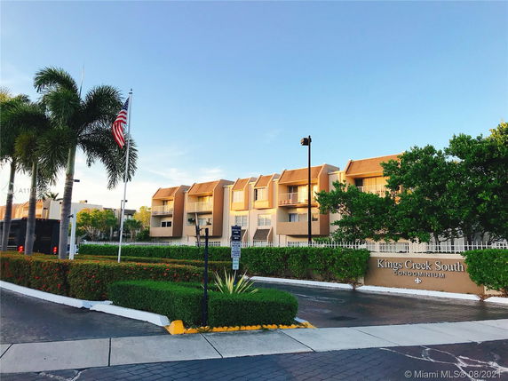 Front view of a condominium complex with multiple floors and balconies.