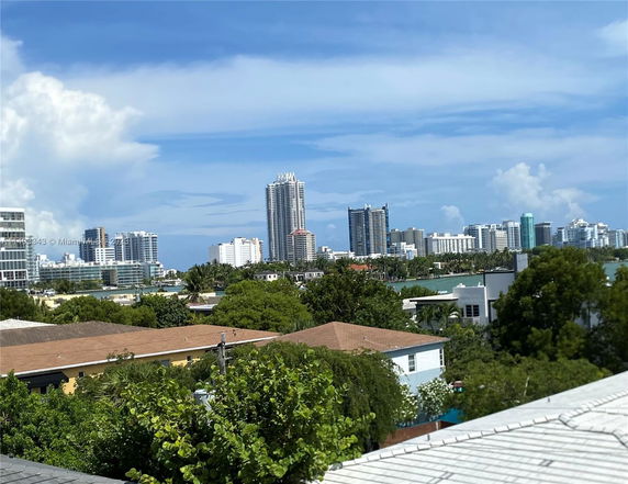View of various buildings including high-rises and residential houses with trees in the foreground.