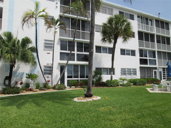 Front view of a multi-story residential building with balconies and windows.