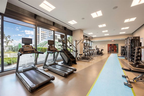 Indoor gym area with various exercise equipment including treadmills and weight machines.