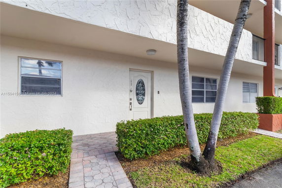 Front view of a residential building with a white door and windows.