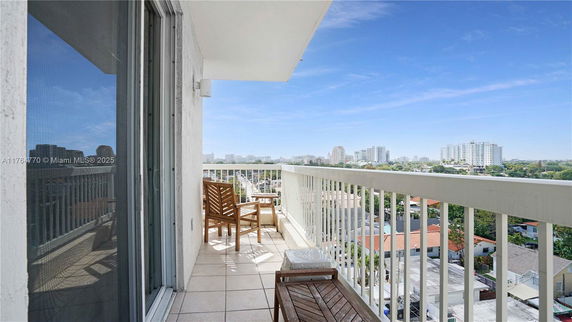 Balcony view overlooking a cityscape with several high-rise buildings.