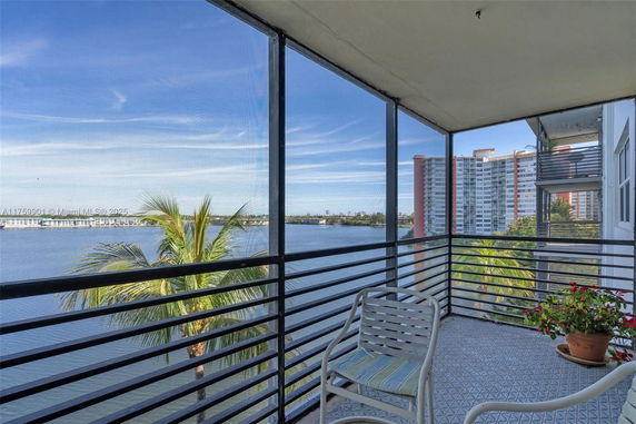 Balcony view overlooking water and nearby tall buildings.