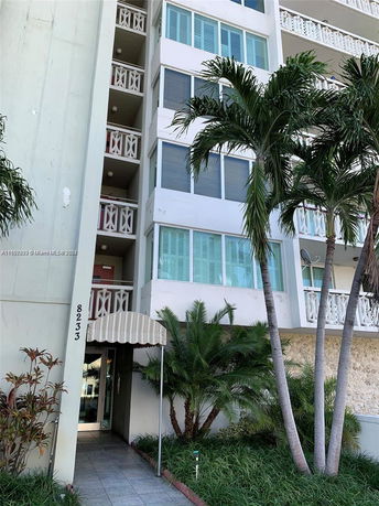 Front view of a multi-story building with balconies and an entrance awning.