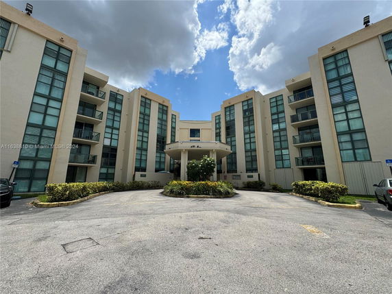 Front view of a multi-story building with large windows and balconies.