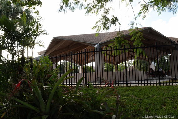 Outdoor view of a fenced area with a large canopy structure.