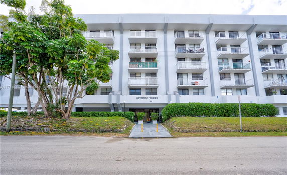 Front view of a multi-story residential building named Olympic Tower with balconies.