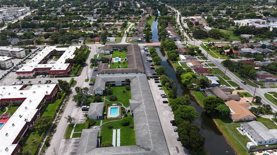 Aerial view of a residential area with apartment complexes, parking spaces, and surrounding neighborhood.