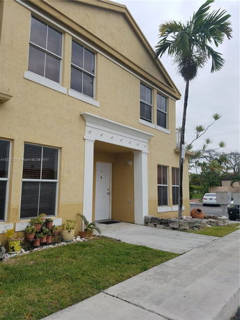 Front view of a two-story yellow house with white trim.