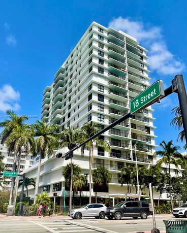 Front view of a multi-story apartment building with balconies.