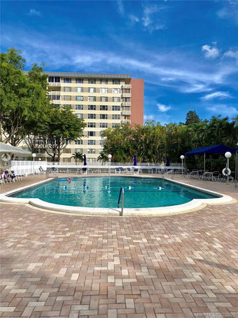 View of a multi-story building with a swimming pool in the foreground.