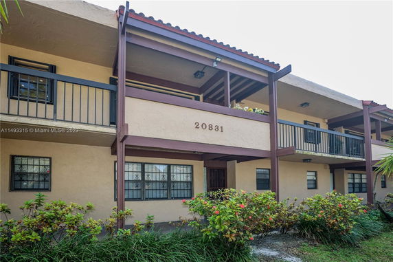 Front view of a two-story building with balconies and windows.