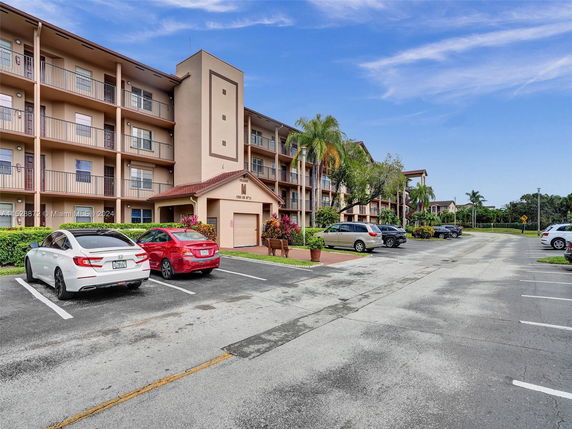 Outdoor parking area in front of a multi-story residential building.