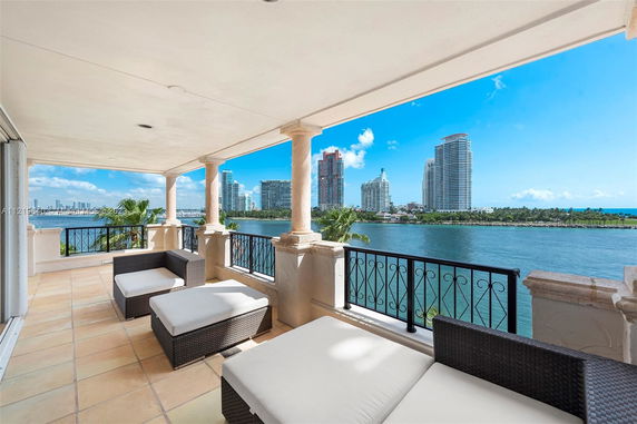 Panoramic view from a balcony overlooking water and city skyline.
