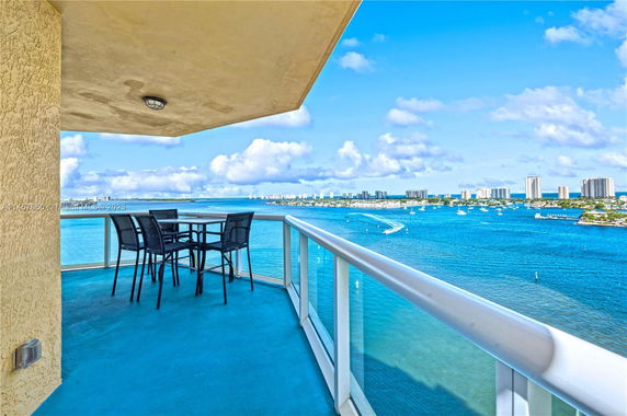 Panoramic view from a balcony overlooking a body of water and distant cityscape.