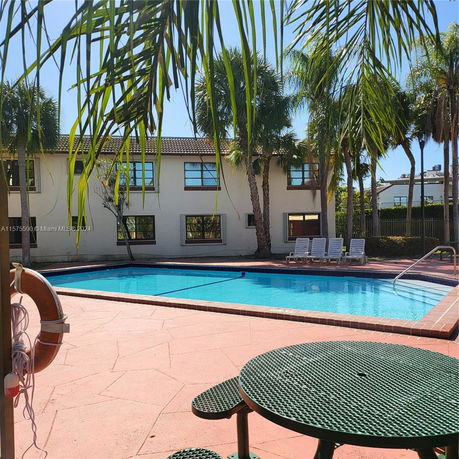 View of a two-story building with a swimming pool in the foreground.