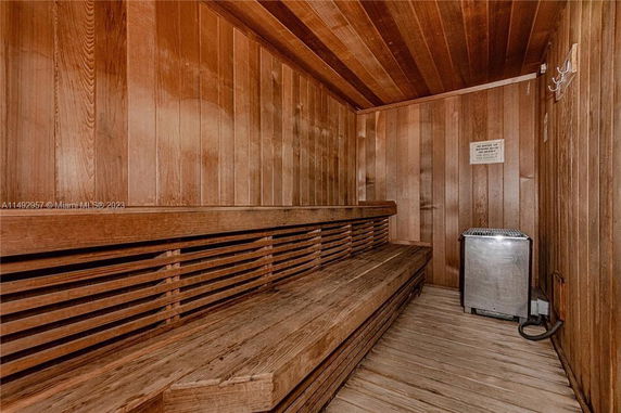 Interior view of a wooden sauna with bench seating and a heater.