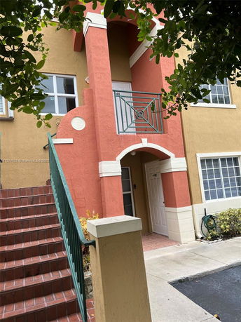 Front view of a two-story building with stairs leading to an upper level entrance.
