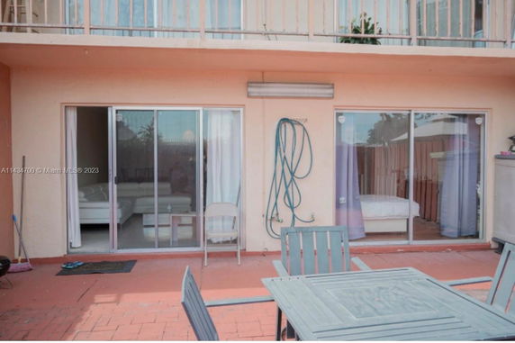 Exterior view of a building with sliding glass doors leading to a patio.