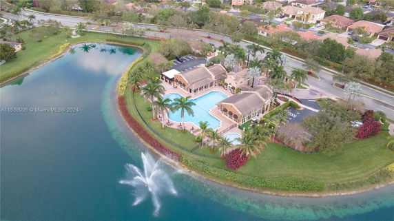 Aerial view of a building complex with a large swimming pool next to a lake.