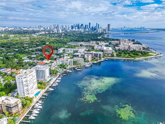 Panoramic view of a coastal city with buildings, waterfront, and skyline.