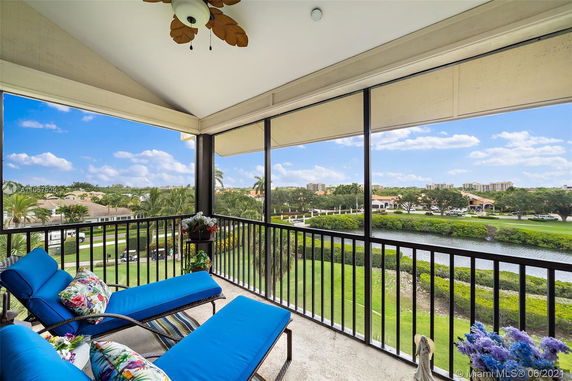 Panoramic view from a balcony overlooking a landscaped area with greenery and water.