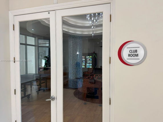 View of a club room with glass doors, including recreational game equipment inside.