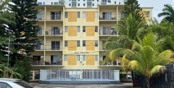 Front view of a multi-story apartment building with balconies.