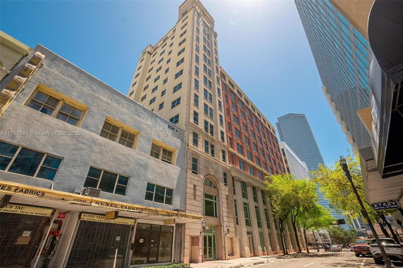 Front view of a tall urban building with multiple stories and large windows.