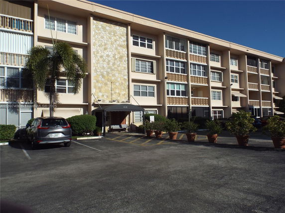 Front view of a multi-story residential building with large windows and balconies.