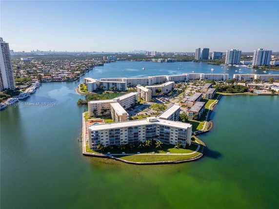 Aerial view of waterfront residential buildings and surrounding water features.