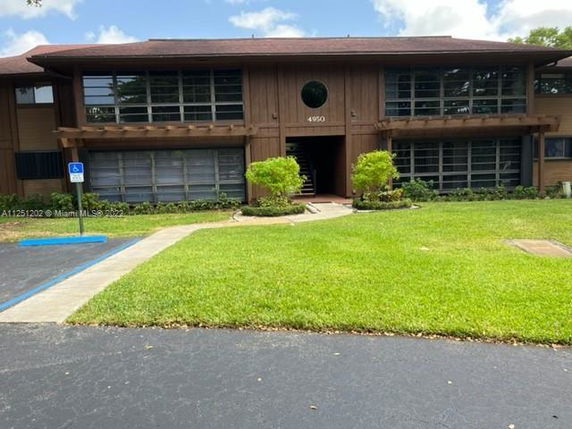 Front view of a two-story building with large windows and a wooden facade.