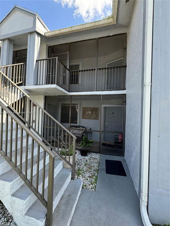 Front view of a two-story apartment building with staircases and balconies.