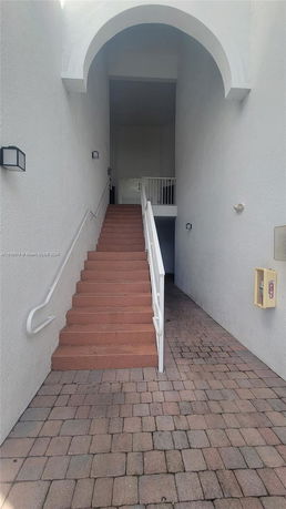 Staircase leading to an elevated entrance with white arches.