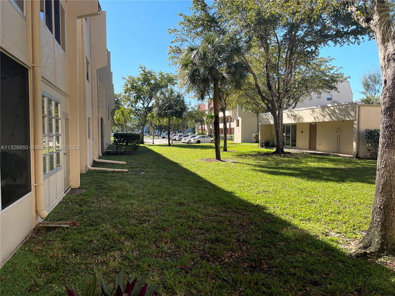 View of buildings with grass and trees in the surrounding area.