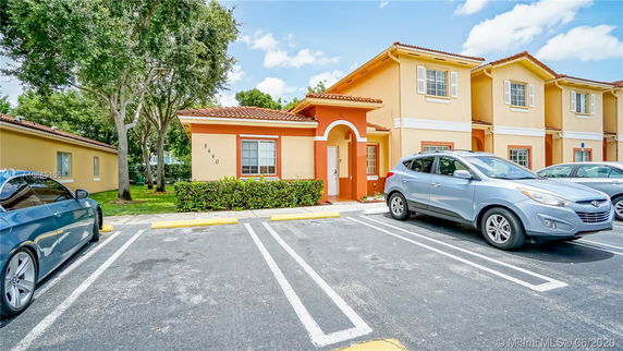 Front view of a two-story residential building with parking spaces.