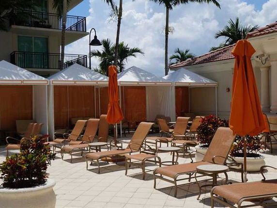 Outdoor pool area with lounge chairs and cabanas.