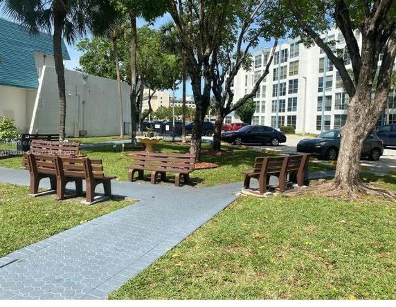 Outdoor seating area with benches and trees near a building.