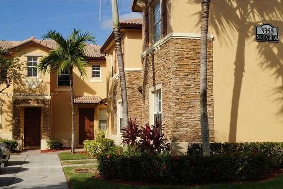 Front view of a two-story house with stucco and stone exterior.