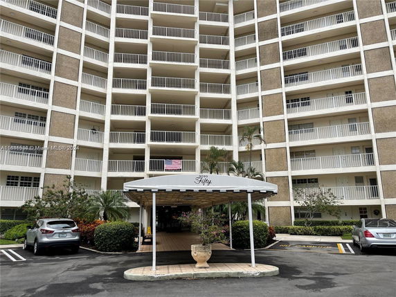 Front view of a multi-story apartment building with balconies.