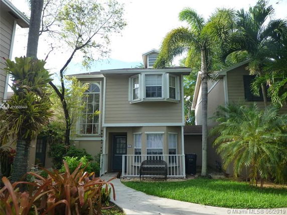 Front view of a two-story house with large windows and a small front porch.