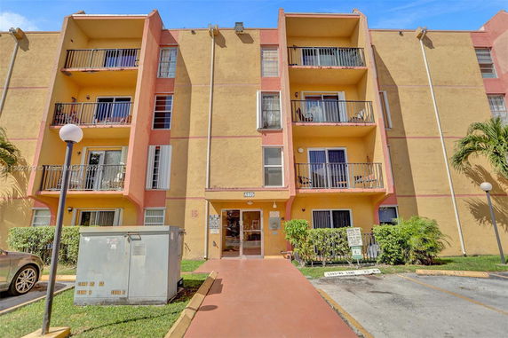 Front view of a multi-story apartment building with balconies.