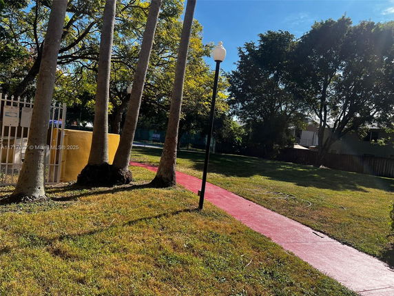 Outdoor area with a walkway, trees, and a lamppost.