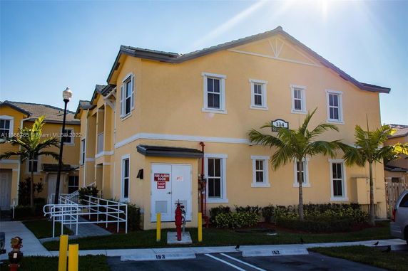 Front view of a two-story yellow building with multiple windows.