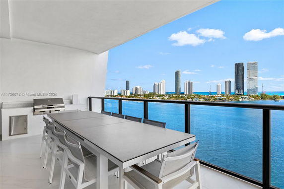 Panoramic view from a balcony overlooking a body of water and city skyline.