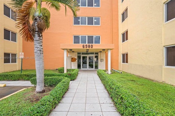 Front view of a multi-story building with glass entrance doors and orange facade.