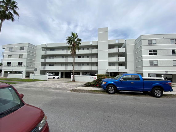 Front view of a multi-story apartment building with balconies.