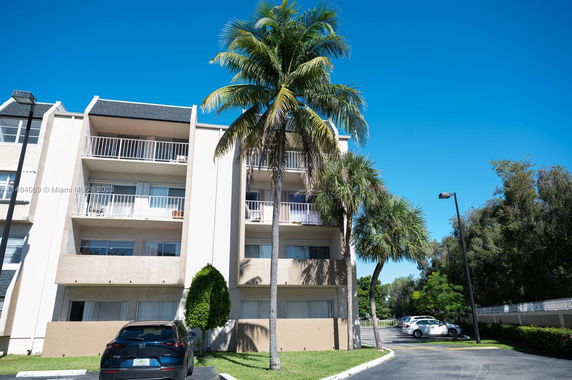 Front view of a multi-story apartment building with balconies.